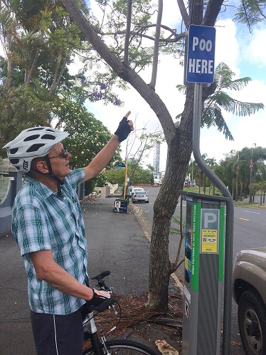 Footbiker Pointing to Parking Sign